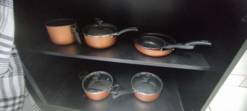 a shelf with pots and pans on it at Casa Ponte Serrada in Joinville
