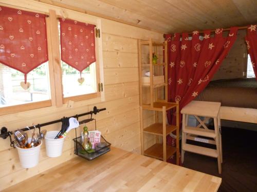 Cette petite chambre comprend un lit et une fenêtre. dans l'établissement Camping des Rochers des Parcs, à Clécy