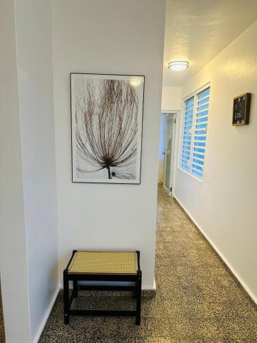 a bench in a hallway with a painting on the wall at El AMANECER DEL ESTE in Fajardo
