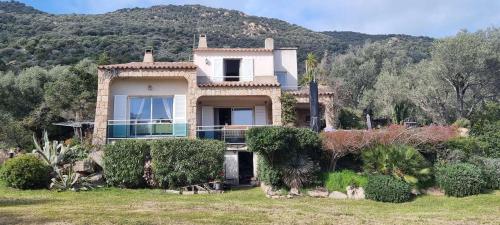 una casa grande con una montaña en el fondo en Maison accès direct plage corse du sud, en Coti-Chiavari