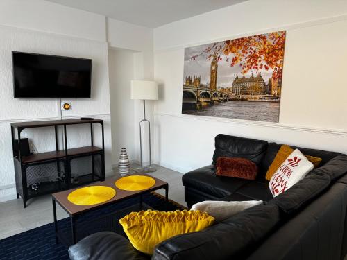 a living room with a couch and a table at Peaceful & Convenient For business Trip & Families holiday & working proffesional-long term deals available , M1 J25-10Min , WI-Fi 500Mb , Netflix , Secure Huge Private garden with 6 cars parking space , Fully equiped kitchen , Few local shops near by in Nottingham