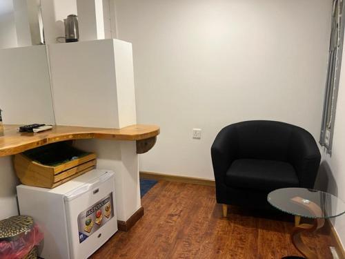 a black chair sitting in a room with a desk at Rooftop Rooms in Male City
