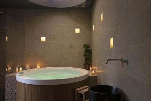 a bathroom with a tub with candles in it at La Maison Coloniale Suite e Zona Wellness free in Cagliari
