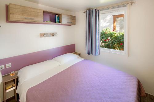 a bedroom with a bed and a window at Camping Baciccia in Ceriale