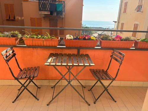 two chairs and a table on a balcony with plants at Il Balcone di Anna - Nervi - 65mq Bilocale in Genoa