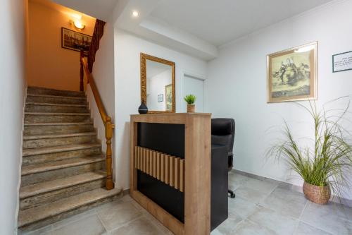 a hallway with stairs and a mirror and a chair at Apartments Villa Sol in Ston