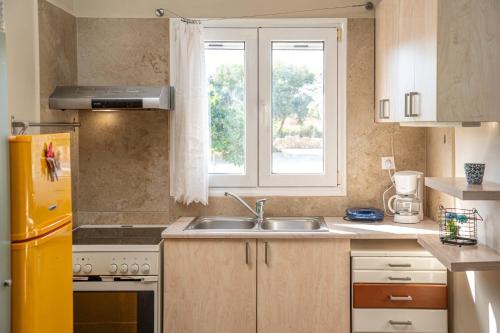a kitchen with a sink and a window at Villa Sorina Kefalonia in Svoronata