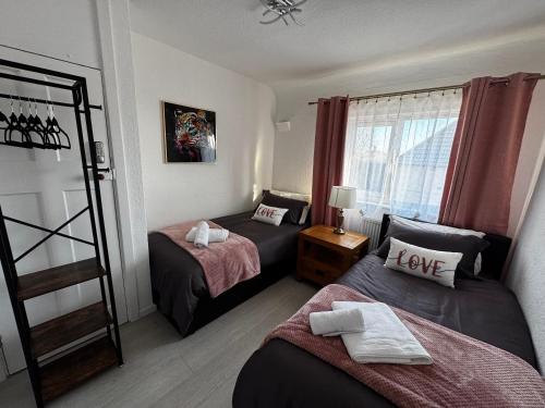 a room with two beds and a window at Peaceful & Convenient For business Trip & Families holiday & working proffesional-long term deals available , M1 J25-10Min , WI-Fi 500Mb , Netflix , Secure Huge Private garden with 6 cars parking space , Fully equiped kitchen , Few local shops near by in Nottingham