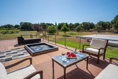 a patio with a table and chairs and a fire pit at Villa Sorina Kefalonia in Svoronata