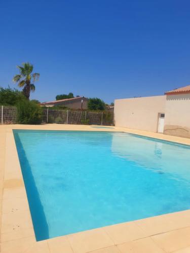une grande piscine avec de l'eau bleue dans l'établissement Villa La Petite Bastide - Résidence familles, à Gallargues-le-Montueux