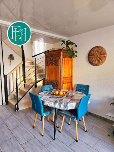 une salle à manger avec une table et des chaises bleues dans l'établissement Villa La Petite Bastide - Résidence familles, à Gallargues-le-Montueux