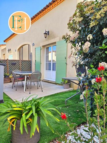 un patio avec une table et des chaises dans une cour dans l'établissement Villa La Petite Bastide - Résidence familles, à Gallargues-le-Montueux