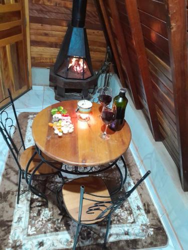 a table with two glasses of wine and a lamp at Pousada e Camping Tio Wil in Extrema