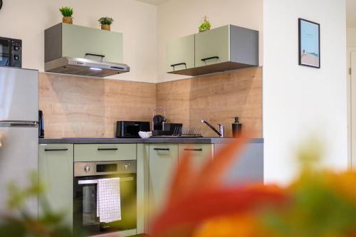 a kitchen with stainless steel appliances and wooden walls at Le 09-Appart'Hôtel-GregIMMO in Montbéliard