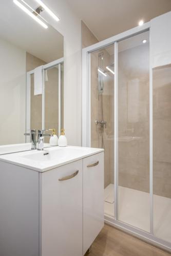 a bathroom with a white sink and a shower at Le 09-Appart'Hôtel-GregIMMO in Montbéliard