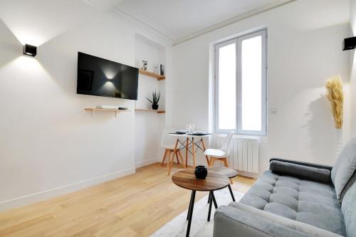un salon avec un canapé et une table dans l'établissement Cosy apartment near Paris, à Saint-Ouen