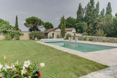 une cour avec une piscine dans la cour dans l'établissement Château de Montardy, à Grand Brassac