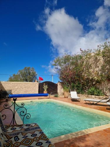 una piscina con una silla junto a una casa en Dar Anouar, en Sidi Kaouki
