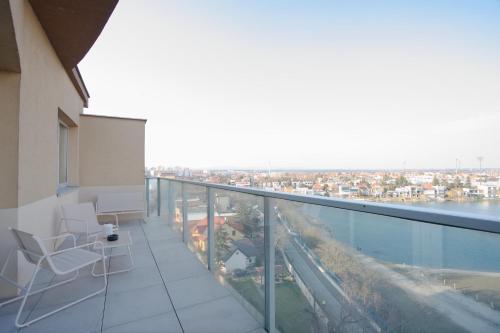 a balcony with chairs and a view of a city at Luxusný Penthouse nad jazerami 230 m2, 2x garáž, WIFI in Senec
