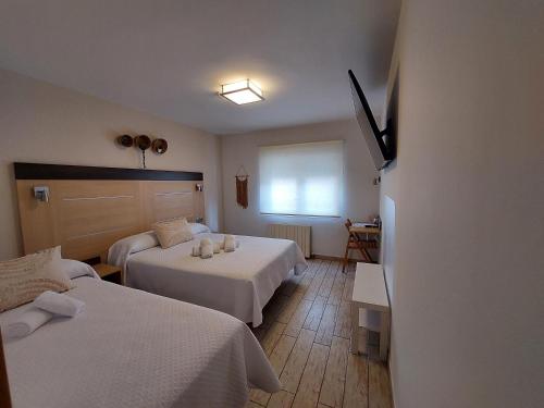 a hotel room with two beds and a window at Pensión Cabezas in Lugones