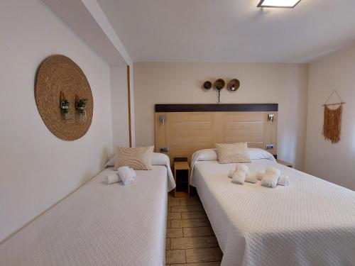 two beds in a room with white sheets at Pensión Cabezas in Lugones