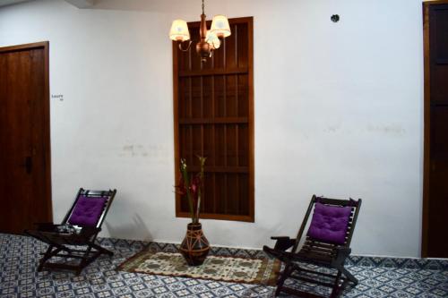two chairs and a vase sitting in a room at Hotel Boutique Iyarí in Palmira