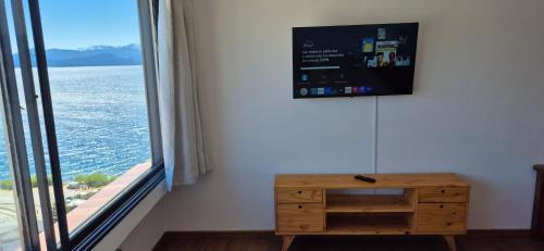 una camera con cassettiera in legno e ampia finestra di Piso 8 Bariloche a San Carlos de Bariloche