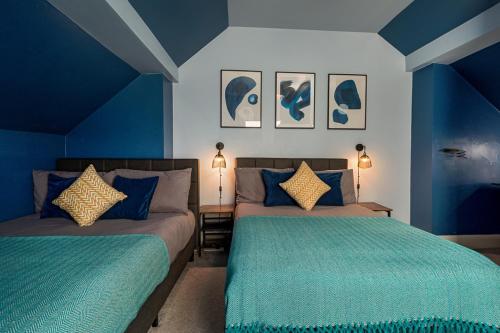 two beds in a room with blue walls at Modern Cozy Retreat-Family-Friendly-Near City & Peak District in Sheffield