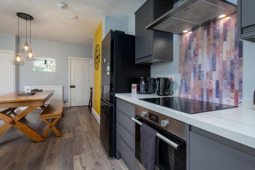 a kitchen with a counter and a table in a room at Modern Cozy Retreat-Family-Friendly-Near City & Peak District in Sheffield