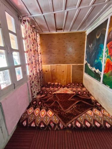 an empty bed in a room with a painting at Shivaay homestay,cafe in Tosh