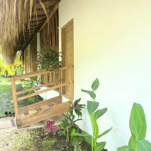 a porch of a house with a wooden bench at la casablanca moñitos in Moñitos