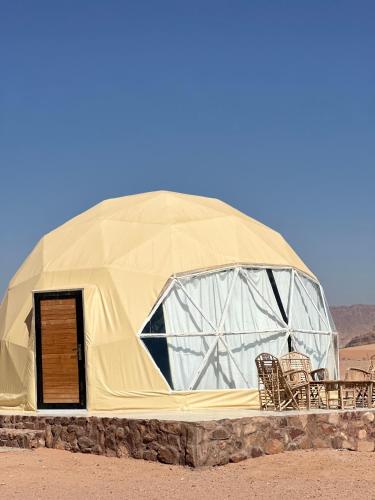 a dome tent with chairs in the desert at Nara Wadi RUM Camp in Wadi Rum