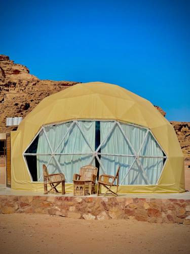a dome tent with chairs in the desert at Nara Wadi RUM Camp in Wadi Rum