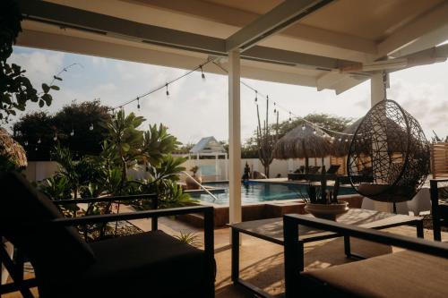 a patio with a pool and a chair and a table at Pura Vida Aruba appartement Cama in Noord