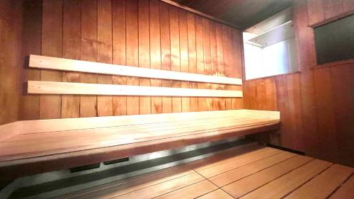 a wooden bench in a room with a window at APA Hotel Osaka Temma in Osaka