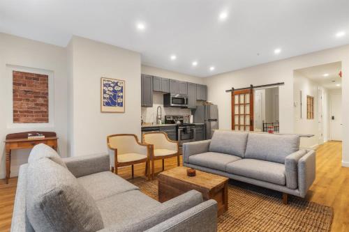 a living room with two couches and a kitchen at Lovely 1-BR Suite in the Heart of Adams Morgan in Washington, D.C.