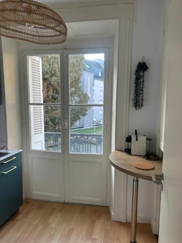 une cuisine avec une porte et un comptoir avec une table dans l'établissement Beau studio au cœur de Dinard, à Dinard