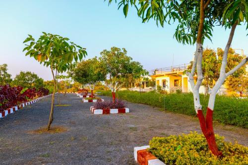 a row of trees in front of a building at AamraKunj Gir Resort in Sasan Gir