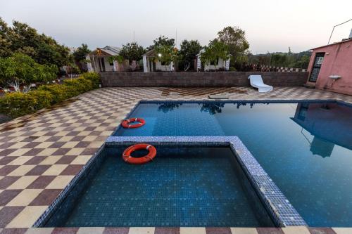 a swimming pool with a red float in the water at AamraKunj Gir Resort in Sasan Gir