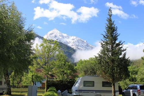 a snow covered mountain with a camper and a van at Alpencamp Kärnten in Kötschach