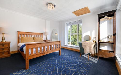 a bedroom with a bed and a chair and a window at Oxendon Oasis- Luxury Hot Tub Retreat in Market Harborough