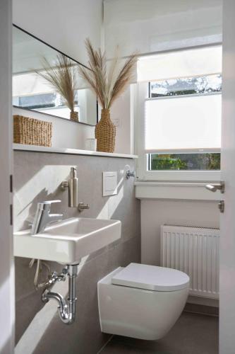 a bathroom with a sink and a toilet and a window at Heideaway in Sprockhövel