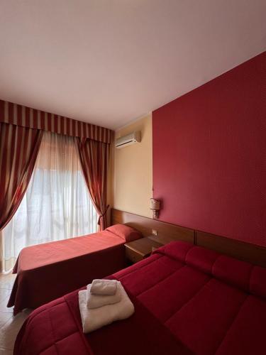 a hotel room with two beds and a window at Villa Verde 2 in Guidonia