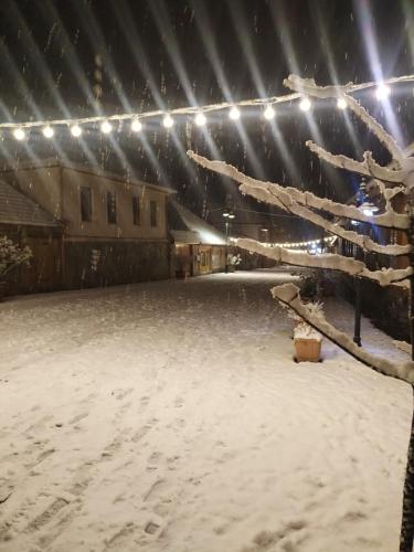 a parking lot covered in snow at night with lights at FHF Haus in Qax