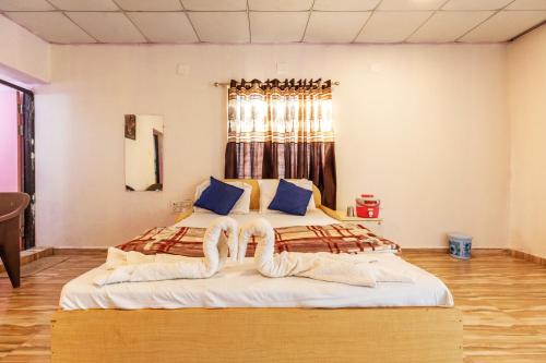 a bedroom with two beds with towels on them at AamraKunj Gir Resort in Sasan Gir
