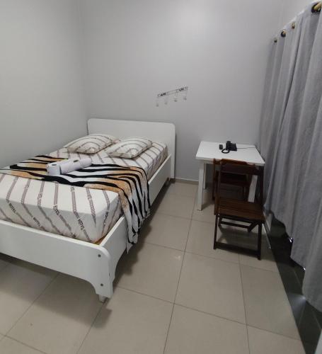 a bedroom with a bed and a small table at Hotel Amanhecer n903- feirinha da madrugada-Brás in Sao Paulo
