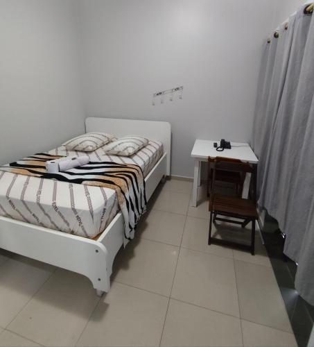 a bedroom with a bed and a small table at Hotel Amanhecer n903- feirinha da madrugada-Brás in Sao Paulo