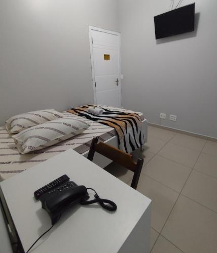 a room with two beds and a phone on a table at Hotel Amanhecer n903- feirinha da madrugada-Brás in Sao Paulo