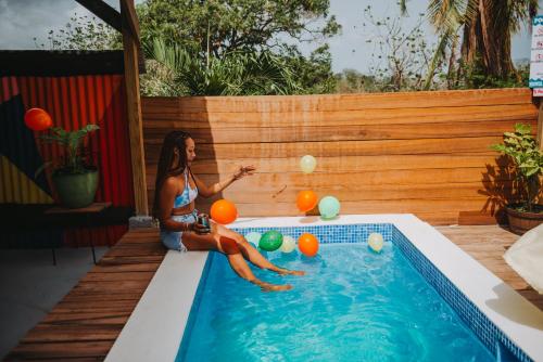 a woman in a bikini playing with balls in a pool at The Local Experience - Kalbas Suite in Choiseul