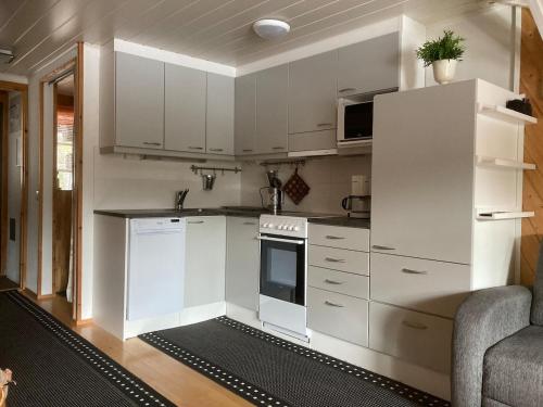 Una cocina con gabinetes blancos y un horno de estufa. en Hulhavanpuisto B2, Iso-Syöte, Pudasjärvi, en Pudasjärvi